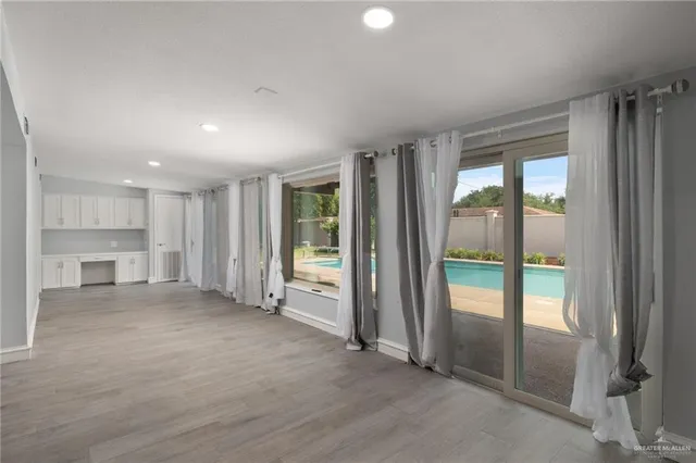 an empty room with windows and a fireplace