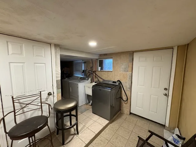 a living room with furniture a flat screen tv and a refrigerator