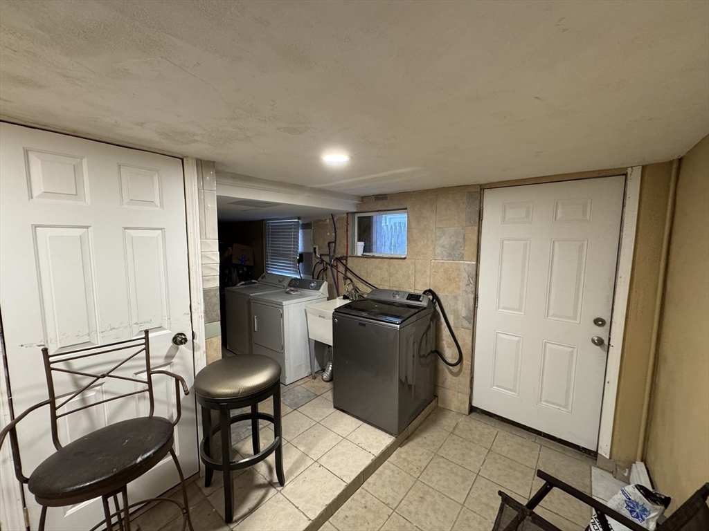27 Harlow Street Worcester, MA 01605 - Photo 27 of 32 a living room with furniture a flat screen tv and a refrigerator
