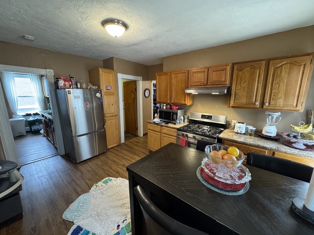 27 Harlow Street Worcester, MA 01605 - Photo 4 of 32 a kitchen with stainless steel appliances granite countertop a stove refrigerator and microwave