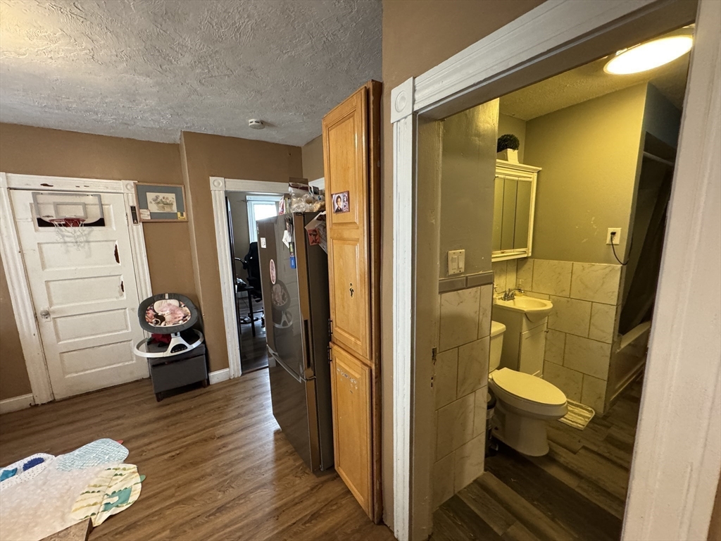 27 Harlow Street Worcester, MA 01605 - Photo 7 of 32 a view of a hallway with wooden floor and a bathroom