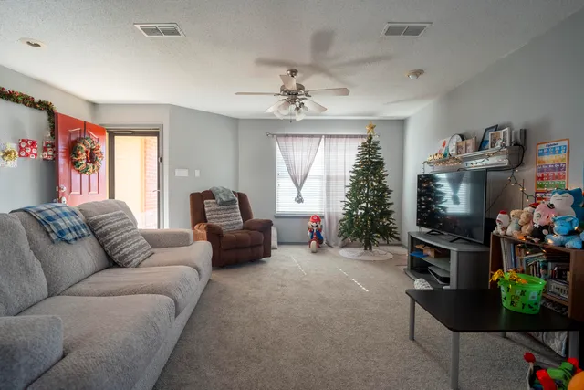 a living room with furniture a window and a flat screen tv