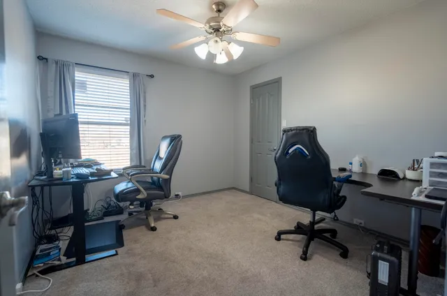 a view of a workspace with furniture and a window