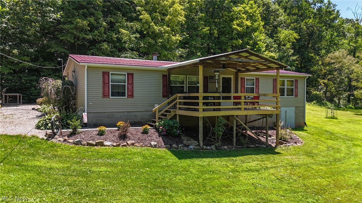 Exterior featuring a covered porch, red metal roof, and light-colored siding