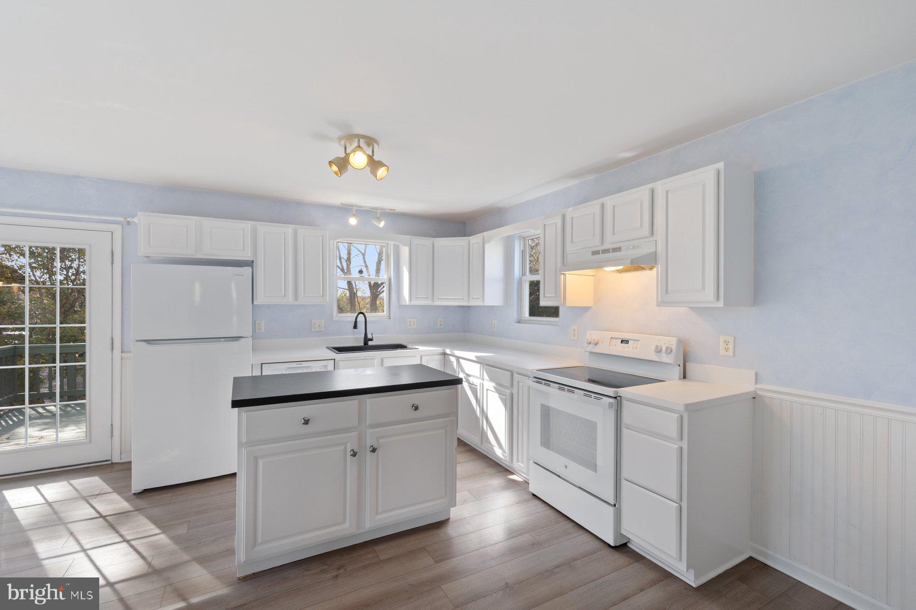 822 East B Street Brunswick, MD 21716 - Photo 10 of 42 a kitchen with a sink a stove cabinets and wooden floor