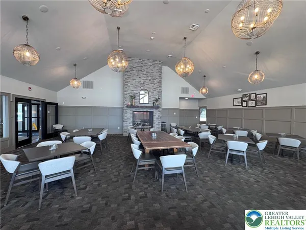 a living room with lots of furniture kitchen view and a chandelier