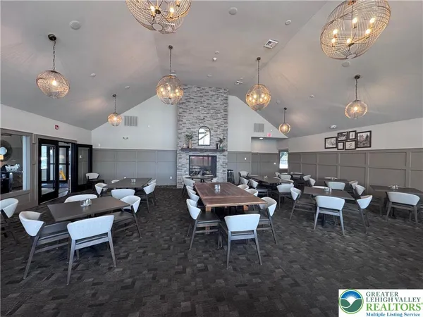 a living room with lots of furniture kitchen view and a chandelier