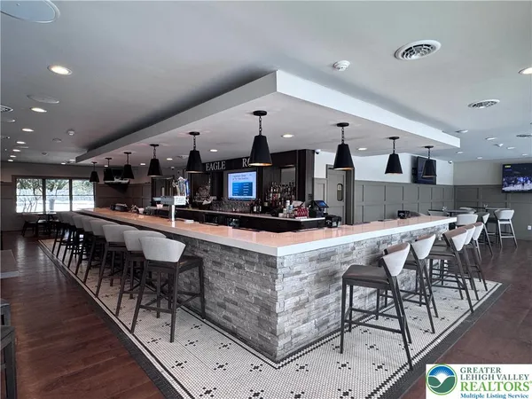 a large kitchen with stainless steel appliances kitchen island granite countertop a table chairs in it and a wooden floors