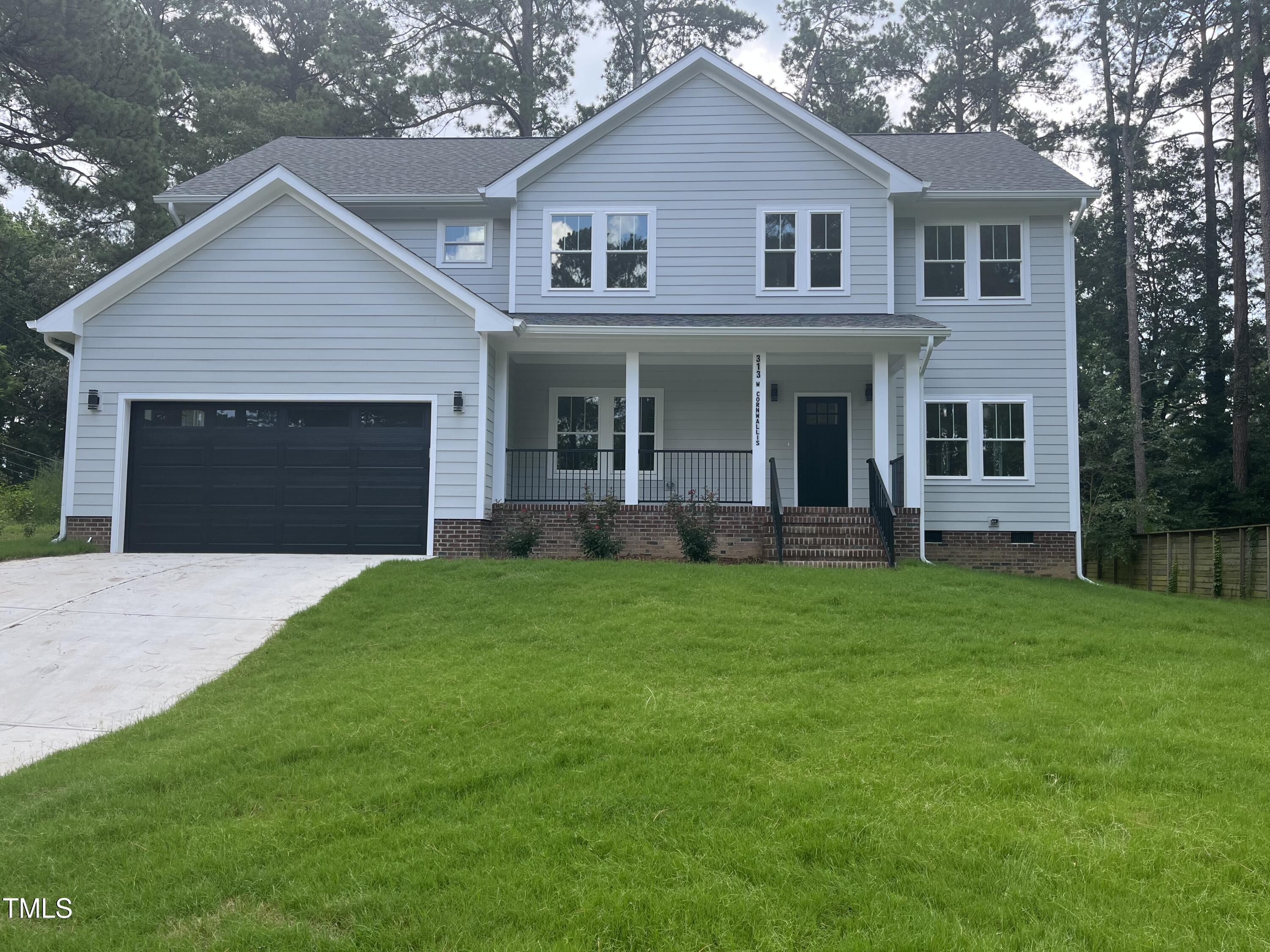 a front view of a house with a garden and yard