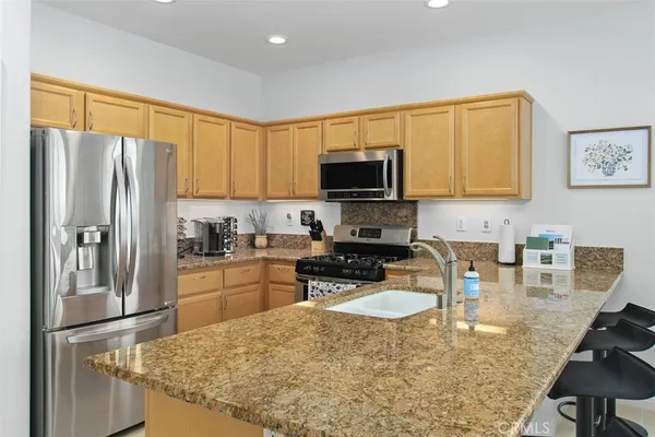 a view of living room kitchen with granite countertop couches and fireplace