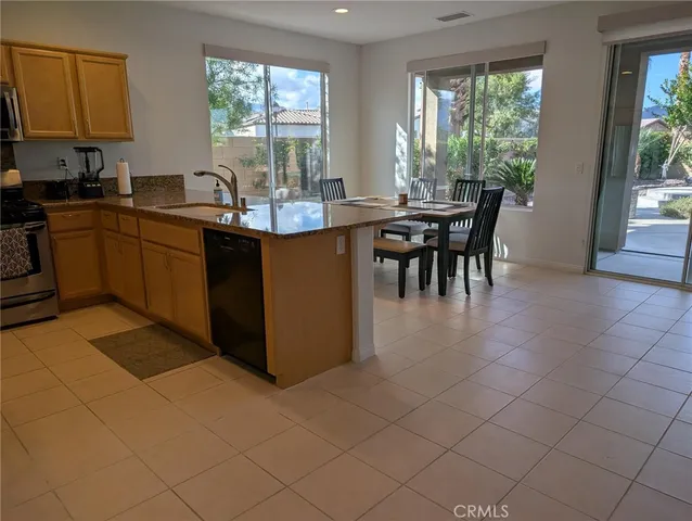 a kitchen with a sink dining table and chairs