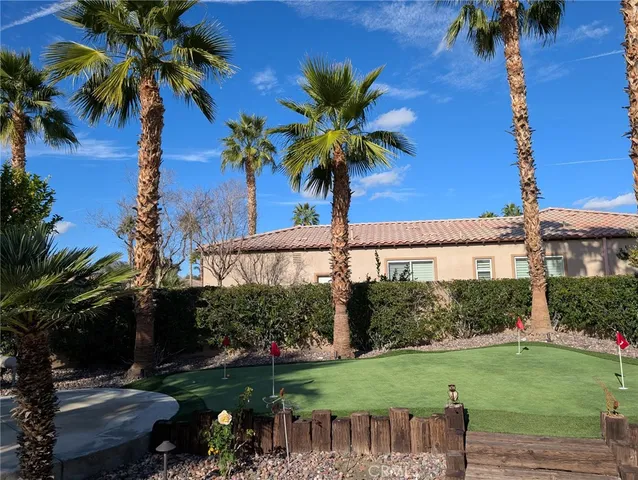 a palm tree sitting in front of a house with a yard