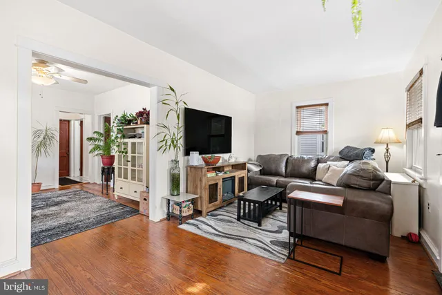 a living room with furniture flat screen tv and wooden floor