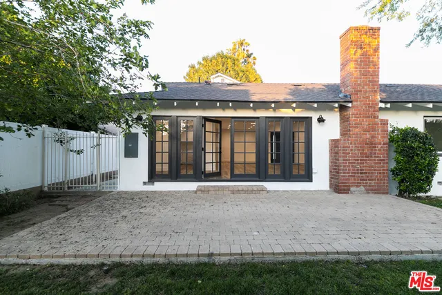 a front view of a house with a garden and plants