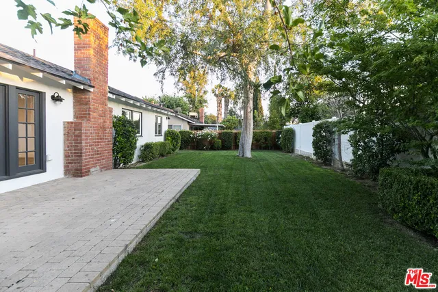 a view of a house with a yard and pathway