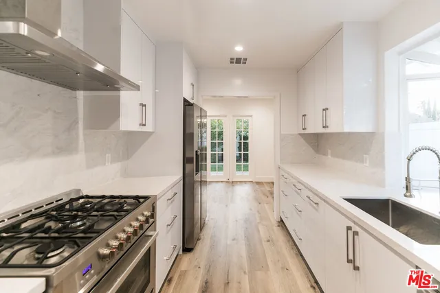 a kitchen with granite countertop a stove and a sink