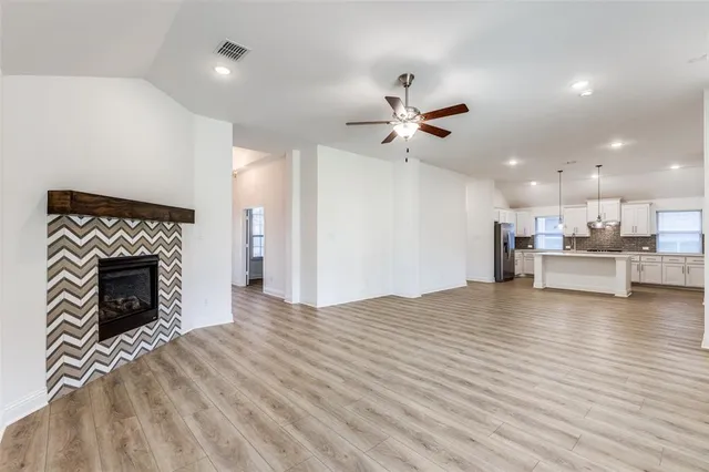 a view of a livingroom with a kitchen and a fireplace