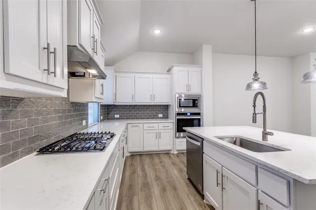 a kitchen with a sink a stove and cabinets