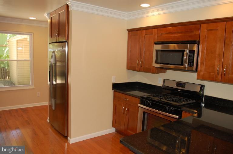 6216 Stevens Forest Road Columbia, MD 21045 - Photo 2 of 30 a kitchen with granite countertop stainless steel appliances a stove microwave and sink
