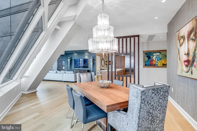 a dining room with furniture a chandelier and wooden floor