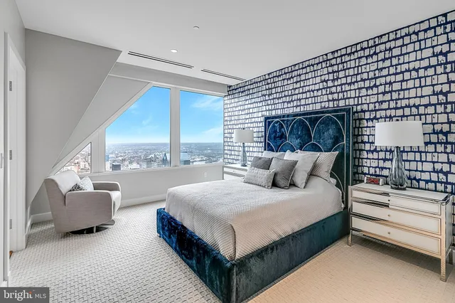 a bedroom with a bed and a large window