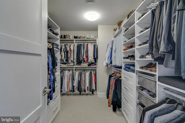 a view of walk in closet with clothes and shoes