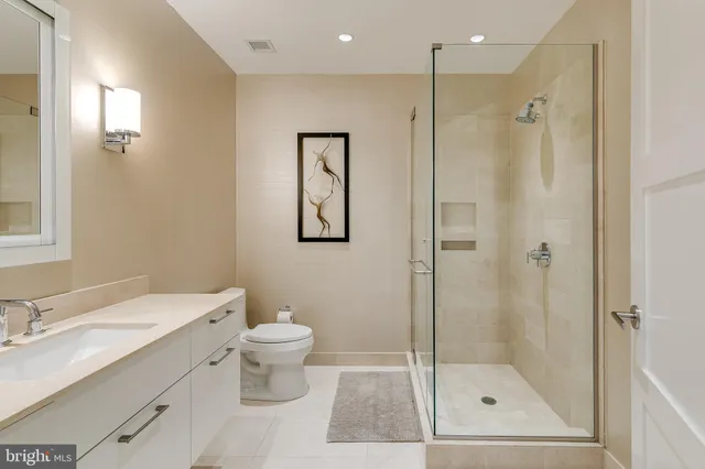 a bathroom with a shower sink vanity mirror and toilet