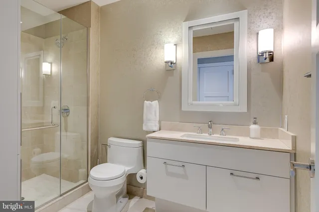 a bathroom with a toilet sink vanity and shower