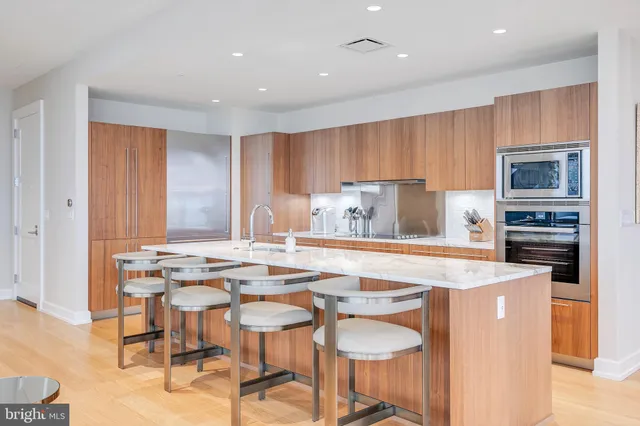 a kitchen with kitchen island a stove a table and chairs in it