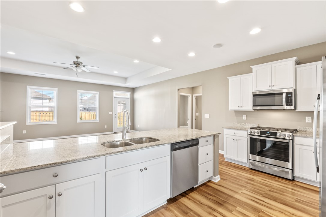 127 Spyglass Lane Pendleton, SC 29670 - Photo 28 of 45 Polished stone countertops complement clean white cabinetry and classic wood floors in this modern culinary space.