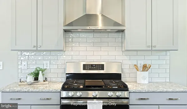a kitchen with granite countertop stainless steel stove and white cabinets