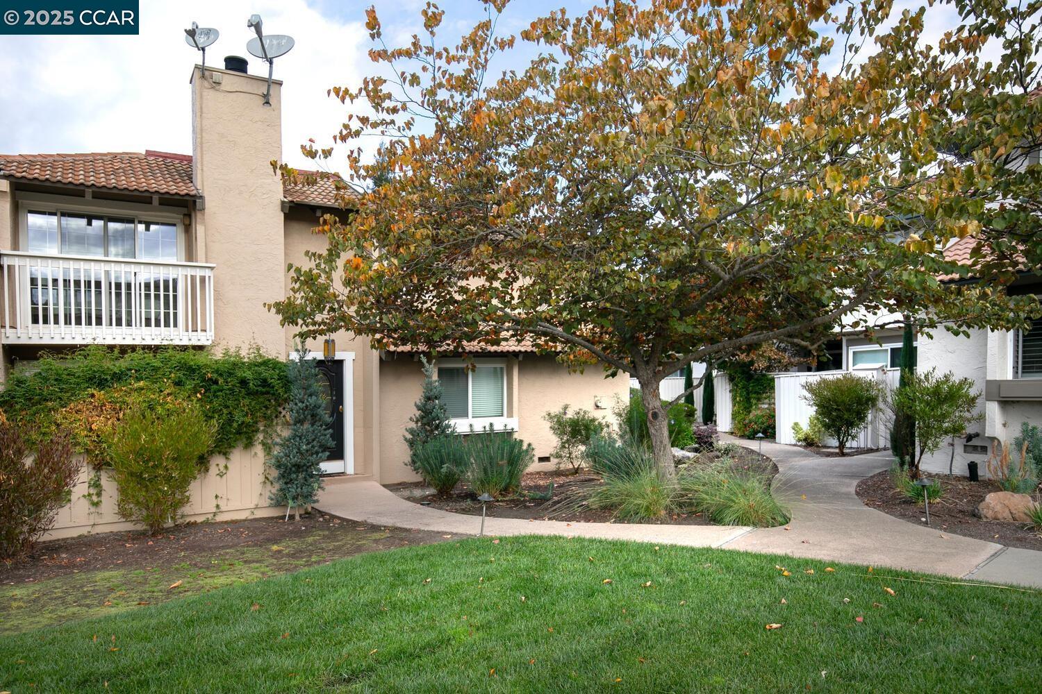 front view of a house with a yard and potted plants