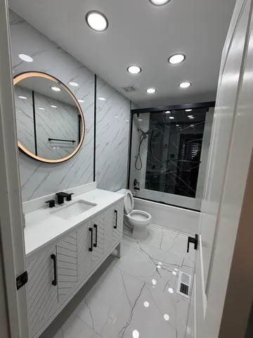 a bathroom with a toilet a sink and a mirror