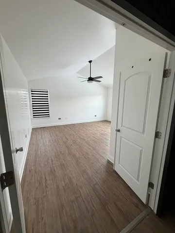 an empty room with wooden floor and white walls