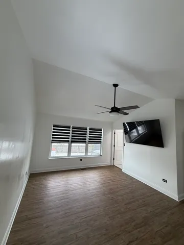 a view of a livingroom with wooden floor and a ceiling fan
