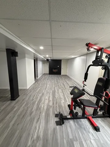 a room with gym equipment and wooden floor