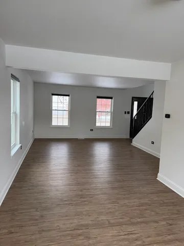 a view of a livingroom with wooden floor and window