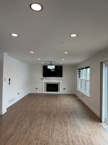 an empty room with wooden floor and fireplace