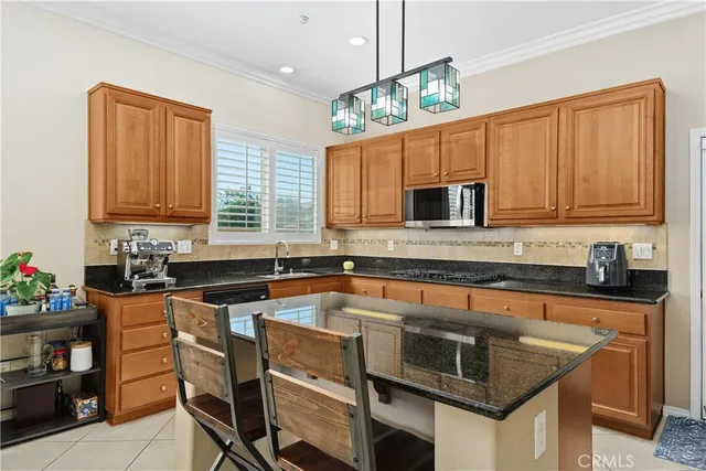 a kitchen with granite countertop a sink stove and microwave