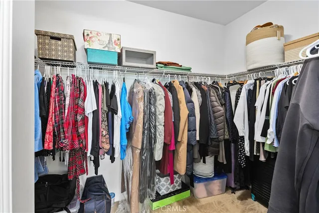 a view of walk in closet with clothes