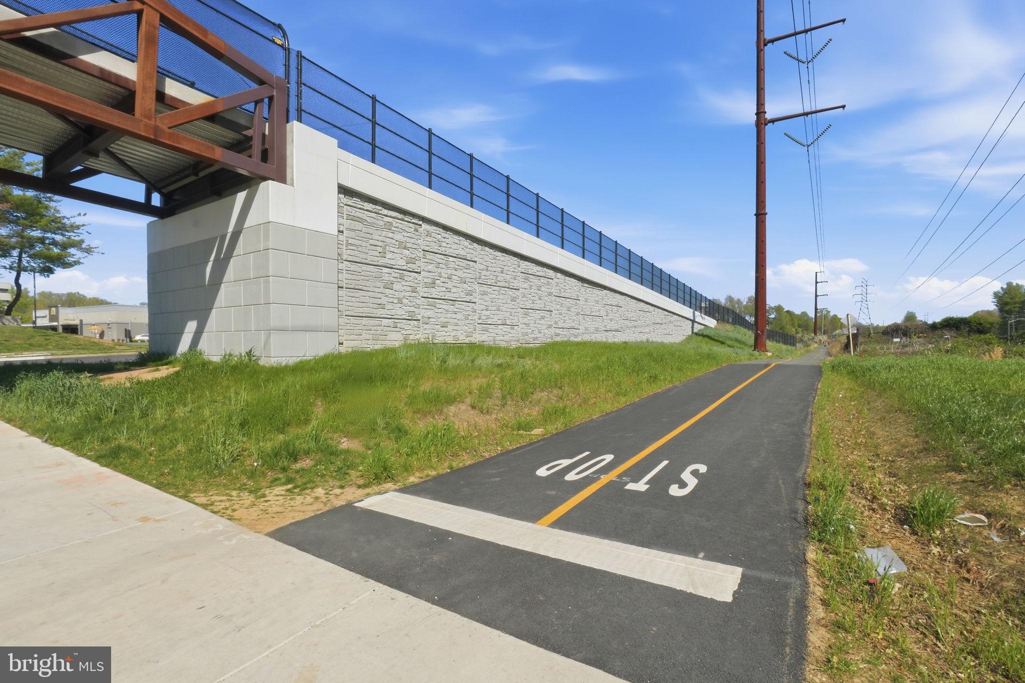 11228 Chestnut Grove Square, Unit 132 Reston, VA 20190 - Photo 21 of 25 Scenic pathway under a modern bridge.