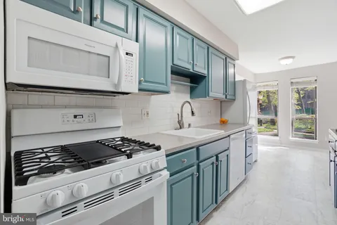a kitchen with stainless steel appliances granite countertop a stove and a microwave