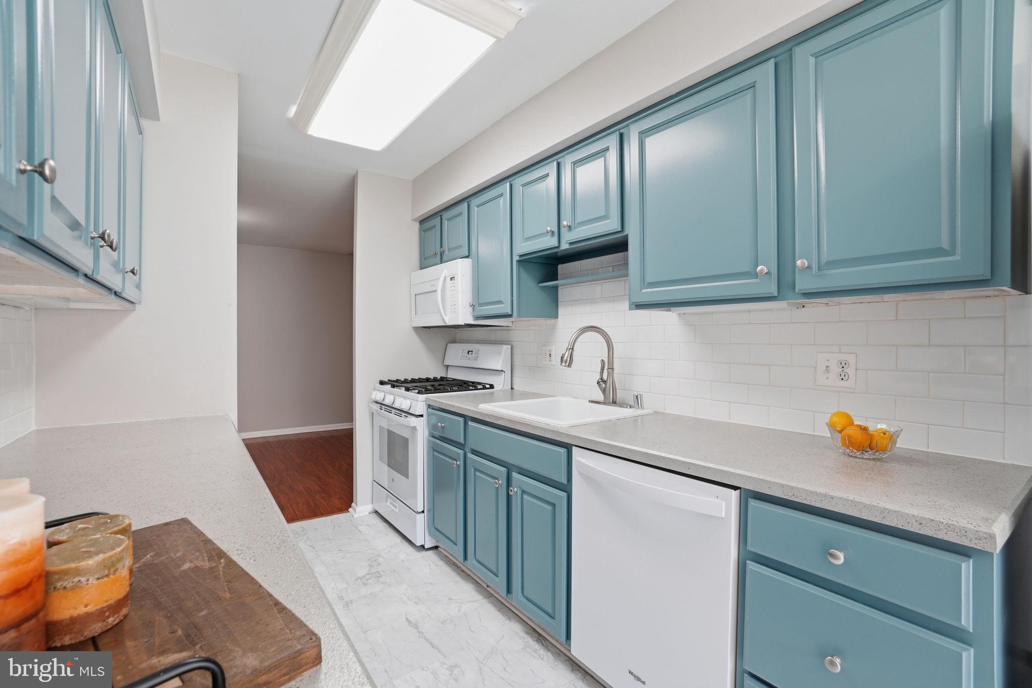11228 Chestnut Grove Square, Unit 132 Reston, VA 20190 - Photo 4 of 25 Charming kitchen with vibrant blue cabinets.