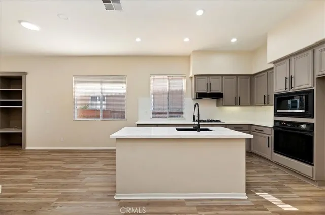 a kitchen with kitchen island stainless steel appliances a sink stove and oven