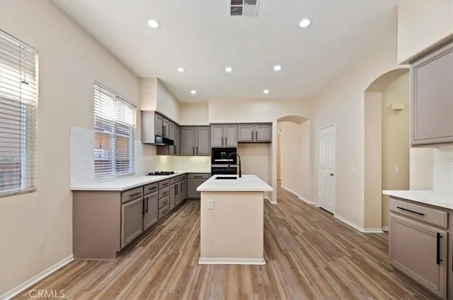 a kitchen with stainless steel appliances a stove top oven a sink and a refrigerator