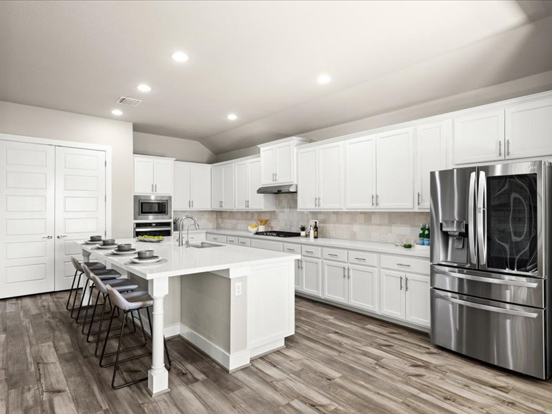 227 Bridge Water Loop Dripping Springs, TX 78620 - Photo 11 of 40 a kitchen with stainless steel appliances a stove a sink dishwasher a refrigerator and white cabinets with wooden floor