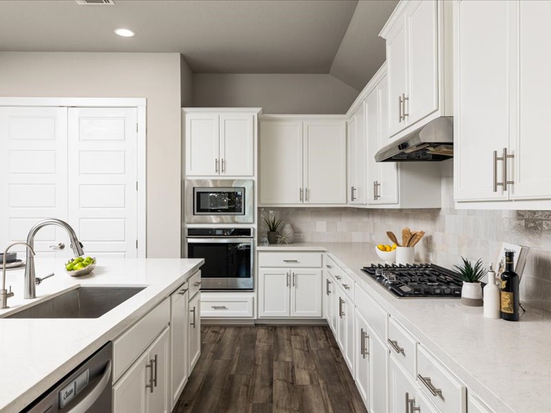 227 Bridge Water Loop Dripping Springs, TX 78620 - Photo 12 of 40 a kitchen with stainless steel appliances a sink a stove and cabinets