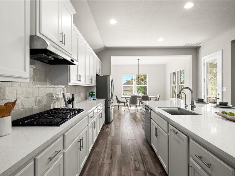 227 Bridge Water Loop Dripping Springs, TX 78620 - Photo 13 of 40 a kitchen with stainless steel appliances a sink stove and cabinets