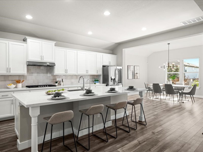 227 Bridge Water Loop Dripping Springs, TX 78620 - Photo 15 of 40 a kitchen with stainless steel appliances stove a dining table and chairs