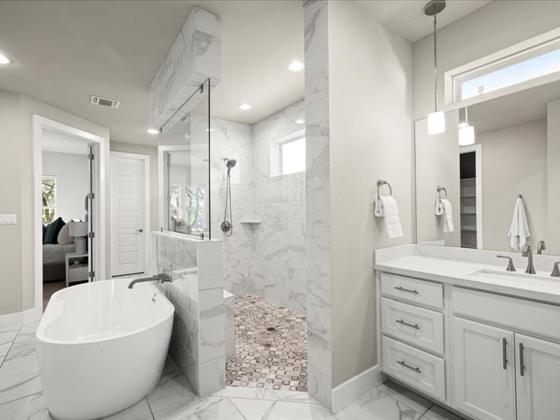 227 Bridge Water Loop Dripping Springs, TX 78620 - Photo 23 of 40 a spacious bathroom with a double vanity sink a mirror and a bathtub